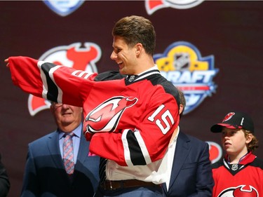 Pavel Zacha puts on his jersey after being selected sixth overall by the New Jersey Devils in the first round of the 2015 NHL Draft on June 26, 2015 in Sunrise, Florida.