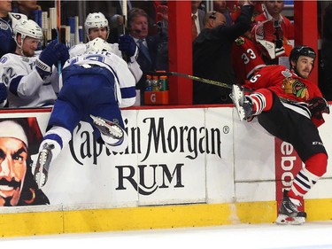 Cedric Paquette #13 of the Tampa Bay Lightning checks Andrew Shaw #65 of the Chicago Blackhawks during Game Four of the 2015 NHL Stanley Cup Final at the United Center on June 10, 2015 in Chicago, Illinois.