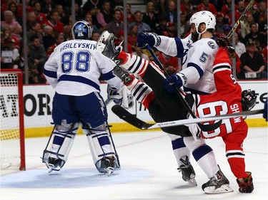 Andrew Shaw #65 of the Chicago Blackhawks collides with Jason Garrison #5 of the Tampa Bay Lightning in the first period during Game Four of the 2015 NHL Stanley Cup Final at the United Center on June 10, 2015 in Chicago, Illinois.