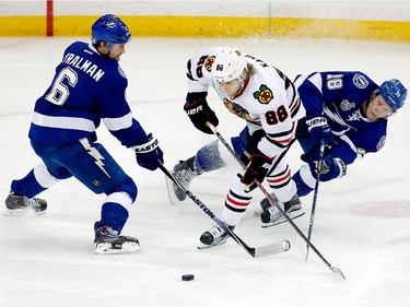 Patrick Kane #88 of the Chicago Blackhawks handles the puck as Anton Stralman #6 and Ondrej Palat #18 of the Tampa Bay Lightning defend in the first period during Game One of the 2015 NHL Stanley Cup Final at Amalie Arena on June 3, 2015 in Tampa, Florida.