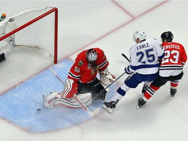 Corey Crawford #50 of the Chicago Blackhawks makes a save in front of Matt Carle #25 of the Tampa Bay Lightning during Game Six of the 2015 NHL Stanley Cup Final at the United Center  on June 15, 2015 in Chicago, Illinois.