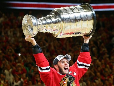 Jonathan Toews #19 of the Chicago Blackhawks celebrates by hoisting the Stanley Cup after defeating the Tampa Bay Lightning  by a score of 2-0 in Game Six to win the 2015 NHL Stanley Cup Final at the United Center  on June 15, 2015 in Chicago, Illinois.