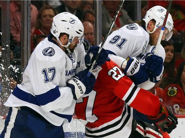 Johnny Oduya #27 of the Chicago Blackhawks gets checked by Alex Killorn #17 and Steven Stamkos #91 of the Tampa Bay Lightning in the second period during Game Six of the 2015 NHL Stanley Cup Final at the United Center  on June 15, 2015 in Chicago, Illinois.