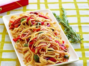 A colourful dish of fettuccine contains slivered red peppers, olives and almonds.