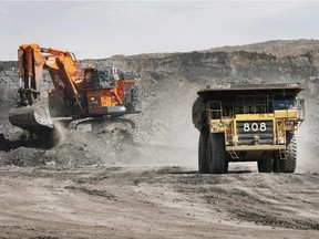 A truck carrying a full load drives away from a mining shovel at the Shell Albian Sands oilsands mine near Fort McMurray, Alta.