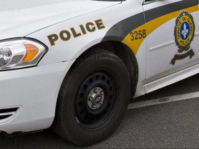 A Surete du Quebec police car is parked in front of a warehouse as police check on maple syrup containers during a police search in St-Nicolas, a suburb of Levis, Que., Friday, October 12, 2012.