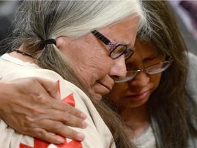 A woman is comforted in the audience during the closing ceremony of the Indian Residential Schools Truth and Reconciliation Commission, at Rideau Hall in Ottawa on Wednesday, June 3, 2015.