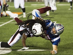 Ottawa Redblacks' Abdul Kanneh, left, takes down Montreal Alouettes quarterback Dan LeFevour during second half CFL football action against the Montreal Alouettes in Montreal, Thursday, June 25, 2015.