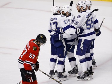 Tampa Bay Lightning's Alex Killorn (17) is congratulated by teammates as Chicago Blackhawks' Trevor van Riemsdyk (57) skates past after scoring during the second period in Game 4 of the NHL hockey Stanley Cup Final Wednesday, June 10, 2015, in Chicago.