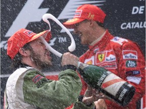 Jacques Villeneuve gives himself a champagne facial after finishing third at the Spanish Grand Prix on April 29, 2001 on the podium in front of Michael Schumacher, who won the race.