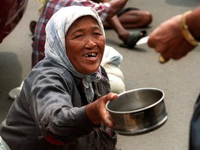 An Indonesian man distributes small notes to beggars.