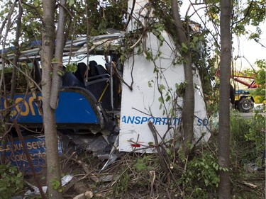 An OPP officer attends the scene of an accident where dozens were injured, several seriously, when a tractor trailer and double-decker bus en route from Montreal to Kingston collided on highway 401 near Cornwall, Ont., on Tuesday, June 23, 2015.