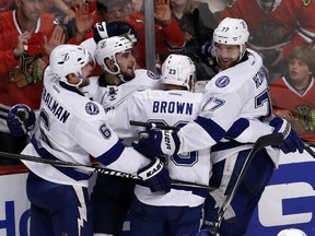 Tampa Bay Lightning's Cedric Paquette, second from left, is congratulated teammates Anton Stralman, left, J.T. Brown, and Victor Hedman, right, after scoring during the third period in Game 3 of the NHL hockey Stanley Cup Final against the Chicago Blackhawks on Monday, June 8, 2015, in Chicago.
