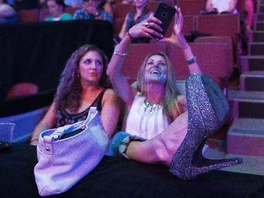 Jordan Thibault (right), with her friend Ashlee Sweeney, takes a picture of her sparkly show prior to the start of the New Kids on the Block show at the Bell Centre in Montreal Tuesday, June 30, 2015.