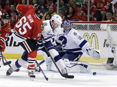Chicago Blackhawks' Andrew Shaw, left, tries to get off a shot as Tampa Bay Lightning's Matt Carle and goalie Ben Bishop, right, defend during the second period in Game 6 of the NHL hockey Stanley Cup Final series on Monday, June 15, 2015, in Chicago.