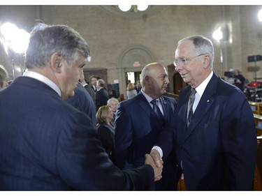Former Quebec premiers Lucien Bouchard (left) and Daniel Johnson shake hands before the state funeral for former Quebec premier Jacques Parizeau in Montreal on Tuesday, June 9, 2015.