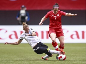 Canada's Rhian Wilkinson (right) and Germany's Simone Laudehr battle for a loose ball during international friendly game at BC Place in Vancouver on June 18, 2014.