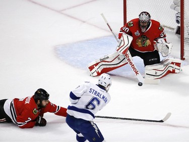 Tampa Bay Lightning's Anton Stralman gets off a shot as Chicago Blackhawks goalie Corey Crawford, top, and Brent Seabrook (7) defend during the first period in Game 4 of the NHL hockey Stanley Cup Final Wednesday, June 10, 2015, in Chicago.