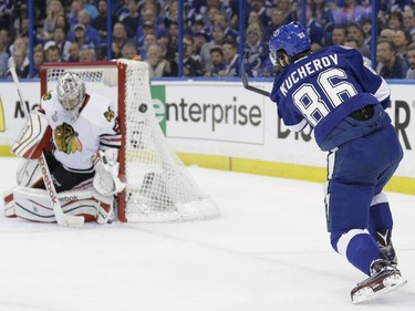 Chicago Blackhawks goalie Corey Crawford (50), left, blocks a shot by Tampa Bay Lightning right wing Nikita Kucherov (86), during the first period in Game 1 of the NHL hockey Stanley Cup Final in Tampa, Fla., Wednesday, June 3, 2015.