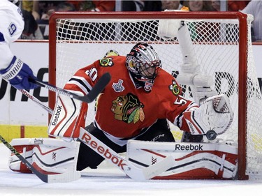 Chicago Blackhawks goalie Corey Crawford deflects a puck during the first period in Game 6 of the NHL hockey Stanley Cup Final series against the Tampa Bay Lightning on Monday, June 15, 2015, in Chicago.