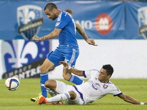 Montreal Impact's Andres Romero, left, is challenged by Orlando City SC's Darwin Ceren during first half MLS soccer action in Montreal, Saturday, June 20, 2015.