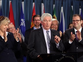 Bloc Québécois Leader Gilles Duceppe, centre, talks about his return as party leader as party president Mario Beaulieu, right, and other party members applaud, during a news conference in Ottawa, Thursday June 11, 2015.
