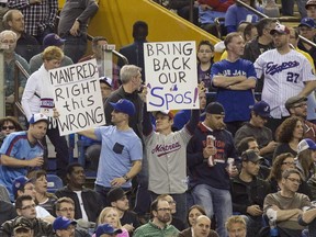 Fans hold up signs as the Toronto Blue Jays face the Cincinnati Reds in Grapefruit League play on April 3, 2015 in Montreal.
