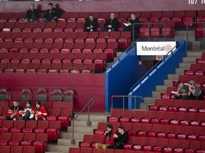 Fans sit among empty seats as they wait for the start of the USA - Germany preliminary round hockey game at the IIHF World Junior Championship Sunday, December 28, 2014 in Montreal.