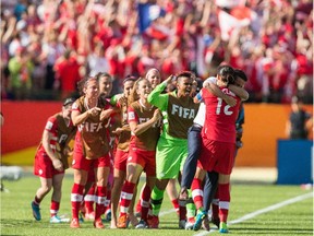 Canada's Christine Sinclair gets a hug from coach John Herdman following her goal during injury time in the opening match of the FIFA Women's World Cup in Edmonton on June 6, 2015.  Canada defeated China 1-0.