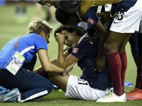 France's Claire Lavogez is consoled by teammates after missing penalty kick that resulted in Germany winning FIFA Women's World Cup quarter-final game at Montreal's Olympic Stadium on June 26, 2015.