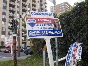 For sale signs stand in front of a condominium Tuesday.