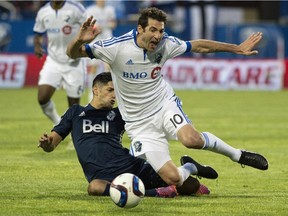 Montreal Impact's Ignacio Piatti is tripped by Vancouver Whitecaps' Matias Laba during first half MLS action Wednesday, June 3, 2015 in Montreal.