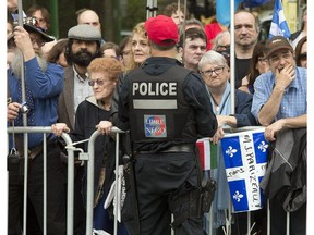 Police were criticized for wearing non-regulation  uniforms, including ball caps, for the funeral for Jacques Parizeau, Tuesday, June 9, 2015 in Montreal.