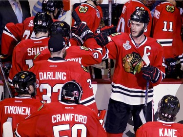 Chicago Blackhawks' Jonathan Toews, top right, celebrates with teammates after the Blackhawks' 2-1 victory over the Tampa Bay Lightning in Game 4 of the NHL hockey Stanley Cup Final Wednesday, June 10, 2015, in Chicago. The series is tied 2-2.