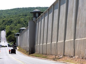 Law enforcement officers stand guard near one of the walls of the Clinton Correctional Facility in Dannemora, N.Y. on Saturday, June 6, 2015. Two convicted murderers used power tools to cut through steel pipes at the maximum-security prison near the Canadian border and escaped through a manhole, Gov. Andrew Cuomo said Saturday.