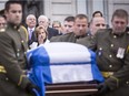 Lisette Lapointe, wife of former Quebec premier Jacques Parizeau, wipes a tear as his casket leaves the National Assembly in Quebec City on Sunday, June 7, 2015.