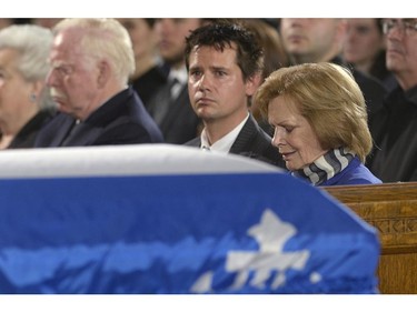 Family members including widow Lisette Lapointe (right) sit by the casket of Jacques Parizeau at the state funeral for the former Quebec premier in Montreal on Tuesday, June 9, 2015.