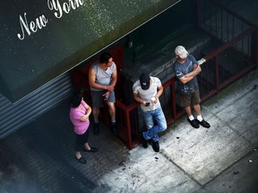 People hang out on a street corner in Manhattan.