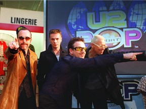 Members of the Irish rock band 'U2' (From L-R:) The Edge, Larry Mullen, Bono and Adam Clayton poses for photographers as they launch their worldwide 'PopMart' tour at at a K-Mart Store in New York City 12 February. The 'PopMart tour, which will be staged on a giant, science fiction, disco, supermarket setting, will open in Las Vegas 25 April and will play in 62 cities in 20 countries.    AFP PHOTO   Timothy A. Clary. POINTING FINGERS AT THE K MART LAUNCH OF THE POPMART TOUR WERE U2 MEMBERS (FROM LEFT THE EDGE, LARRY MULLEN, BONO AND ADAM CLAYTON
USED 20010528 THE EDGE GUITAR.; LARRY MULLEN JR. DRUMS; BONO VOCALS; ADAM CLAYTON BASS.