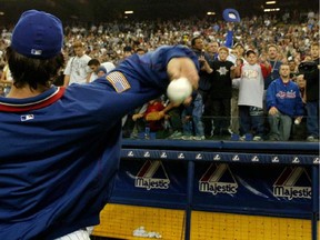 A Montreal Expo throws a ball to a screaming crowd.