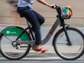 A cyclist rides a Bixi bicycle on de Maisonneuve boulevard in Montreal on Tuesday, August 12, 2014.