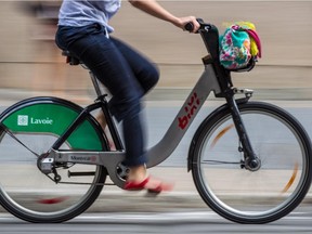 A cyclist rides a Bixi bicycle on de Maisonneuve Blvd.