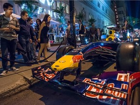 Party-goers check out Sebastian Vettel's Renault-powered, Red Bull race car parked outside the Ritz Carlton Hotel on Sherbrooke St West for an F1 party on June 6, 2014.