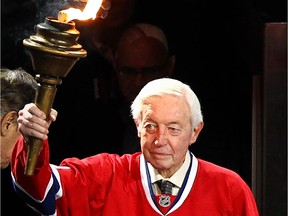 Former Canadiens great Jean Béliveau holds a torch before the start of the opening game of the NHL season against the Toronto Maple Leafs at Montreal's Bell Centre on Jan. 19, 2013.