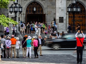 A tourist takes a photograph of Notre-Dame Basilica in Old Montreal.