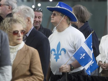 A mourner with a Quebec flag walks towards the coffin of former Quebec premier Jacques Parizeau at the Caisse de dépôt et placement du Québec in Montreal, on Saturday June 6, 2015.