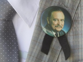 With a pin on his lapel a mourner leaves the public visitation of former Quebec premier Jacques Parizeau, in Montreal on Saturday June 6, 2015.
