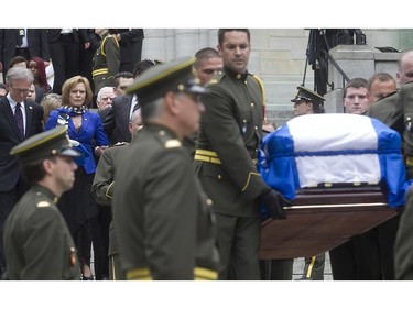 Lisette Lapointe, wife of former Quebec Premier Jacques Parizeau, carries a Quebec flag as she and family members march behind Parizeau's coffin after the church ceremony at Saint-Germain d'Outremont Church in Montreal on Tuesday June 09, 2015.