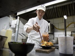 Chef/owner Hachiro Michael Fujise prepares poutine at his restaurant Thazard.