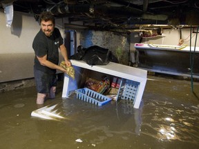 Pascal Quirion cleans out a freezer in his girlfriend's basement while cleaning up after a flood in Coaticook June 10, 2015.